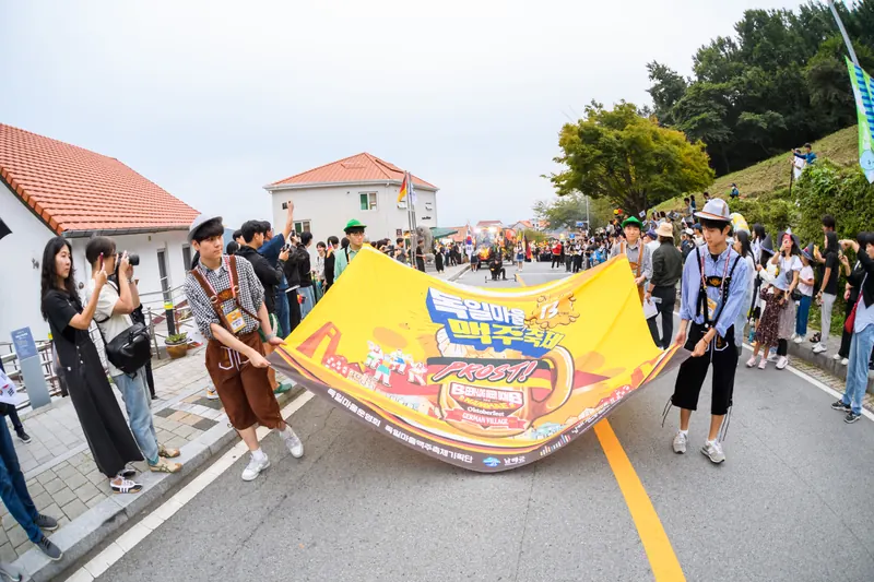 축제 현수막을 펼쳐 들고 행진하는 퍼레이드 행렬