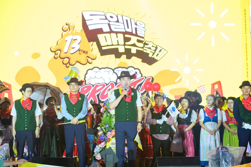 축제 무대 앞에 선 전통 의상 차림의 출연진