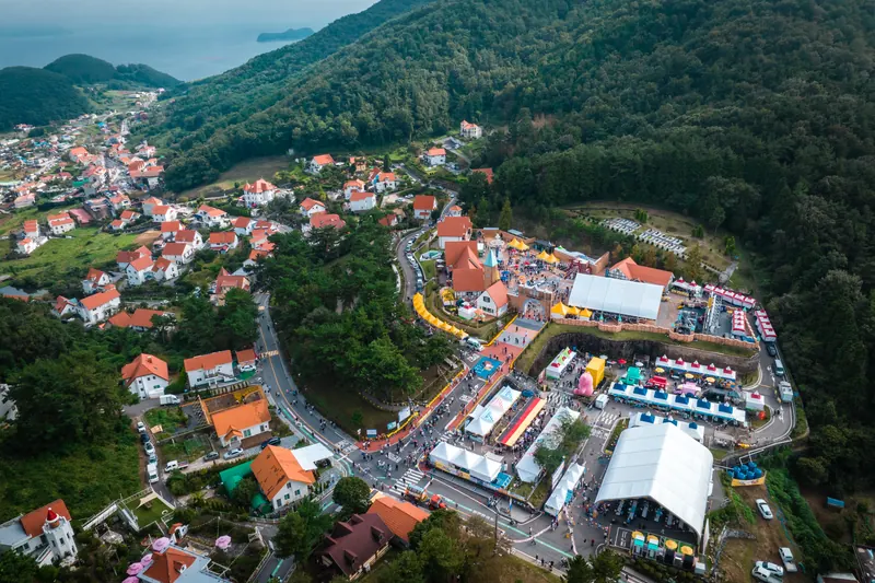 산자락에 자리한 독일마을과 축제장을 내려다본 항공 사진