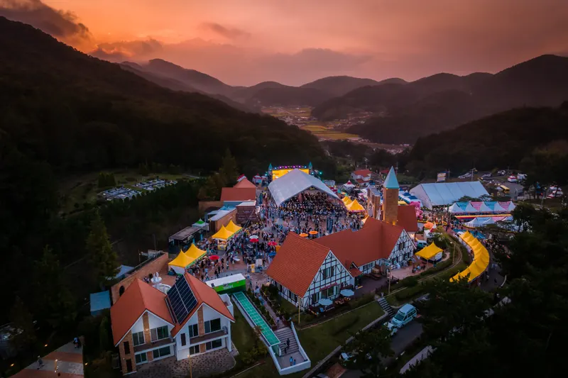 노을 속 독일마을과 축제장을 내려다본 항공 사진